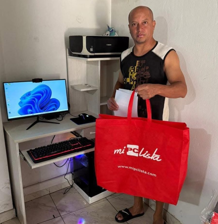 Cliente en su casa con la bolsa de su compra junto a su PC gamer instalada